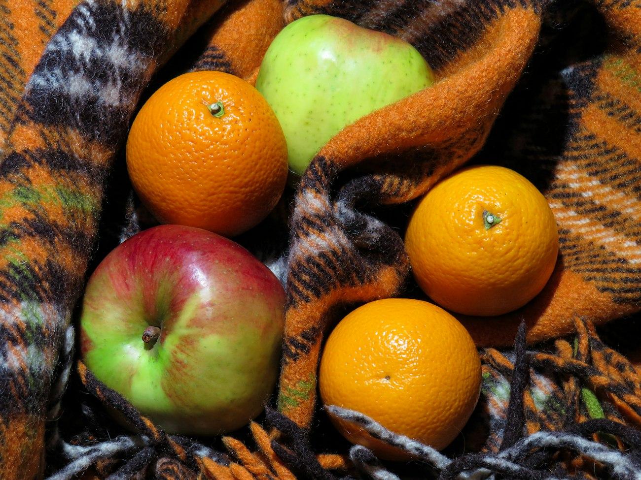 Apples and oranges arranged in a basket for gifting