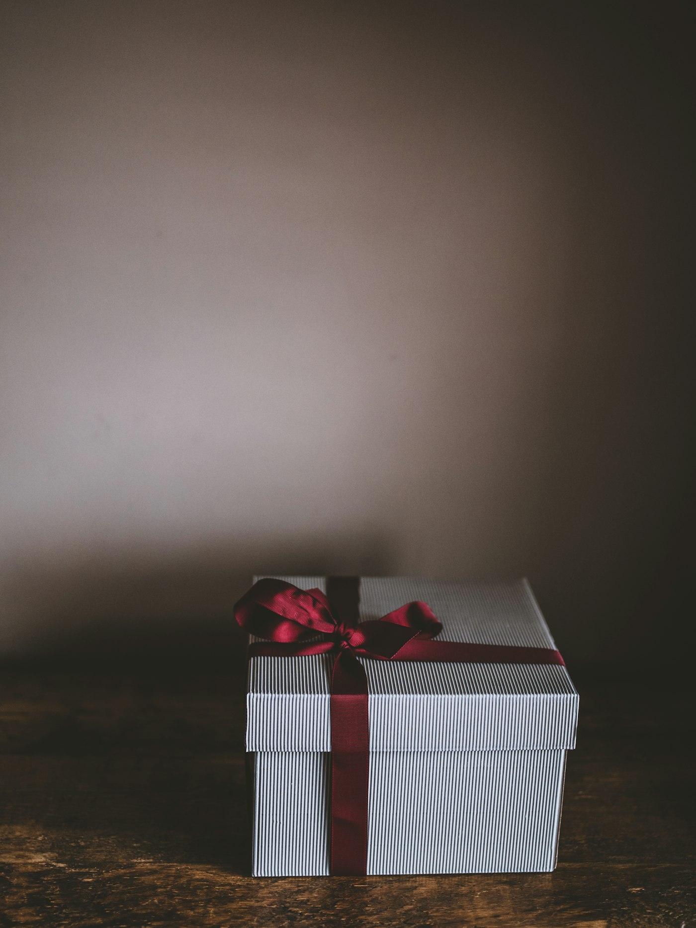 Two people exchanging a carefully wrapped gift box