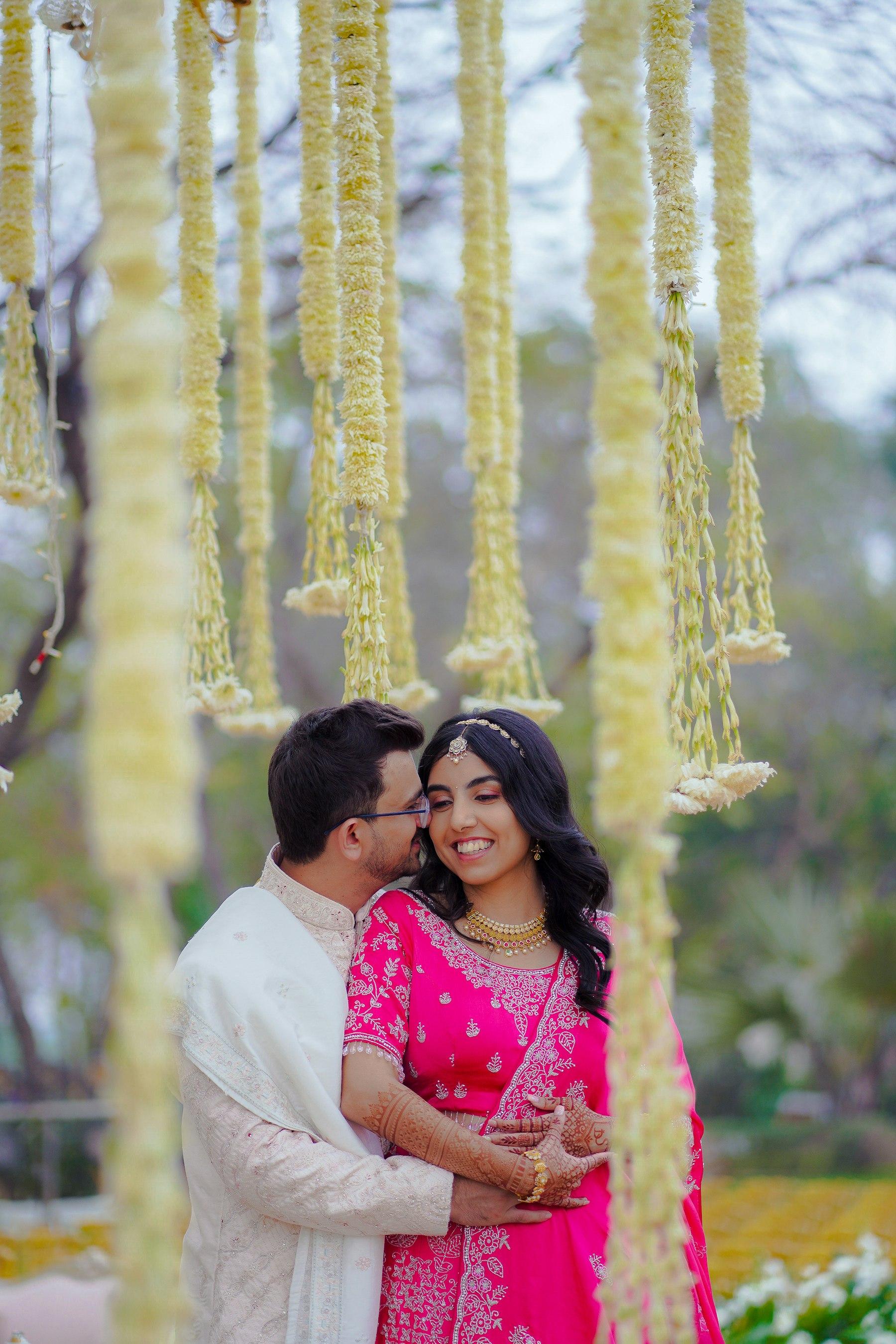 A couple under floral decorations at an Indian wedding ceremony